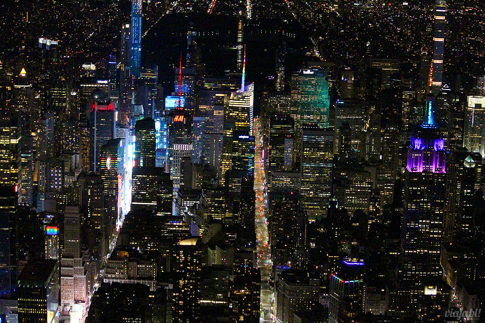 Voo de helicóptero em Nova York: Times Square à esquerda, Empire State à direita e Central Park escuro ao fundo