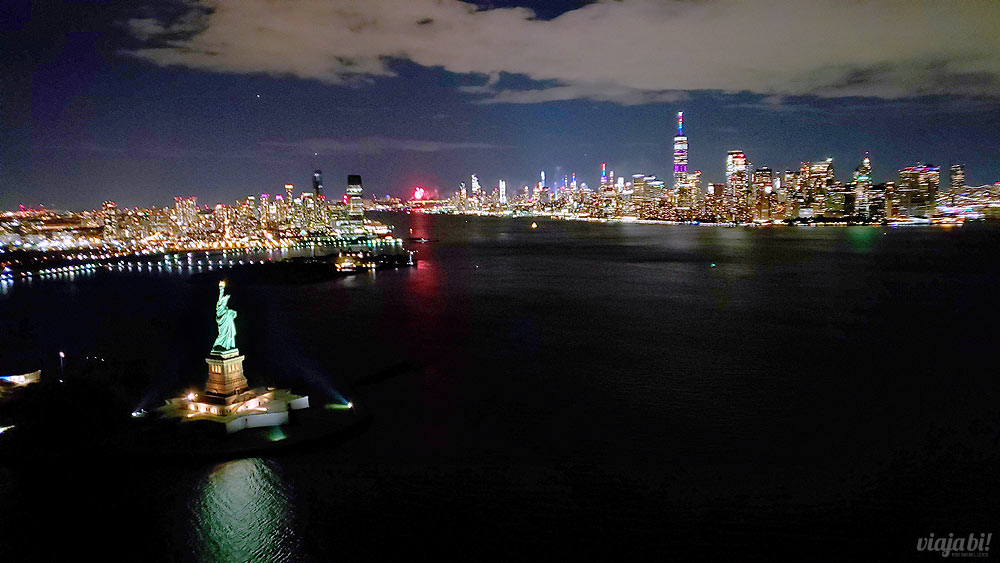 Estátua da Liberdade, Manhattan e o skyline de Nova York e, ao fundo, fogos encerrando a World Pride NYC