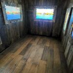 4 telas exibindo vídeos animados dentro de uma sala de madeira