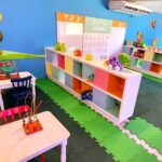 Espaço para crianças, com tapete EVA, decoração colorida, personagens nas paredes, mesinhas e estantes baixas
